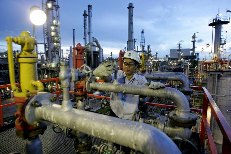 FILE PHOTO: A technician checks pipelines at Bangchak oil tanks in Bangkok September 7, 2005.   REUTERS/Sukree Sukplang/File Photo